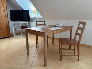 a dining room with a table and two chairs at Ferienwohnung mit Küche und Bad in Hollenbach