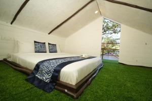 a bedroom with a large bed in the grass at Beachouse Beachfront Cottages And Suites in Calangute