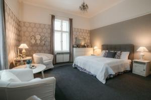 a bedroom with a bed and a couch and chairs at Château Josefův Důl in Josefŭv Dŭl