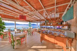 a restaurant with tables and chairs and a counter with food at Hotel Sonne - Adults Only in Kaş