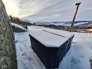 a large black box sitting in the snow at Domek Wilk w Górach Sowich in Jugów