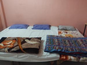 a bed with two blankets and pillows on it at affordable homes in Prayagraj