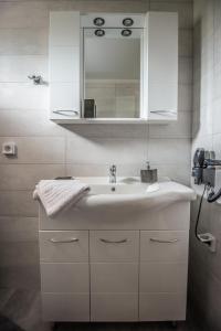 a bathroom with a white sink and a mirror at Rock Garden Villa in Marantochori +37 photos
