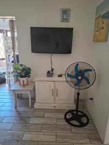 a fan in a living room with a flat screen tv at Uvongo Sea Scapes Holiday Apartment in Margate