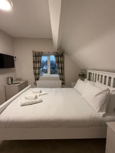 a bedroom with a large white bed with towels on it at The Mary Arden Inn in Stratford-upon-Avon