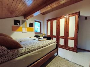 a bedroom with a bed and a wooden ceiling at Casa del Capitano Hilton in Isolaccia