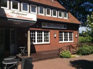 een bakstenen gebouw met tafels en stoelen ervoor bij Hotel Haus Schürmann in Dorsten