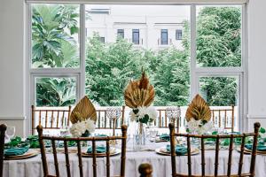 a table with a white table cloth and chairs and a window at The Ancestry Suites in Wasig