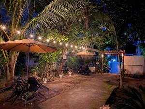 eine Terrasse mit Stühlen und Sonnenschirmen in der Nacht in der Unterkunft ELEN INN - Malapascua Island Air-conditioned Room2 in Malapascua + 43 Fotos