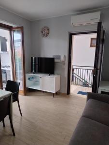 a living room with a flat screen tv and a couch at Petit Appartament in Policoro