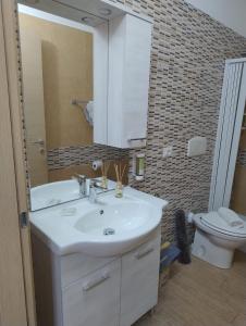 a bathroom with a sink and a mirror and a toilet at Petit Appartament in Policoro +6 photos