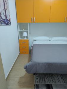 a bedroom with a bed and a yellow cabinet at Petit Appartament in Policoro