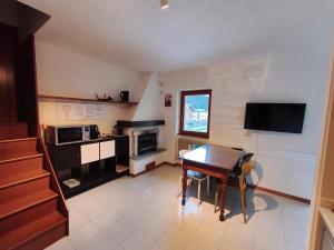 a living room with a table and a kitchen at Casa del Capitano Hilton in Isolaccia +18 photos