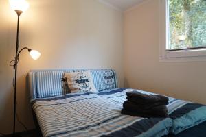 a bedroom with a bed with a lamp and a window at Tiny House - Camping am Lippesee in Paderborn