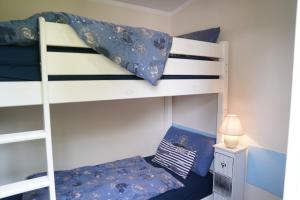 a bedroom with two bunk beds with blue sheets at Tiny House - Camping am Lippesee in Paderborn