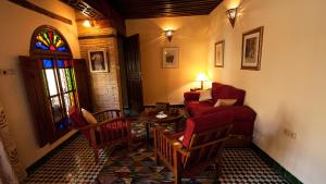 un soggiorno con divano rosso e tavolo di Ryad Salama a Fes