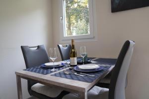 a dining room table with a bottle of wine on it at Tiny House - Camping am Lippesee in Paderborn