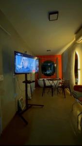 a living room with a tv and a table and chairs at Amsterdam Lofts Deluxe in Poços de Caldas