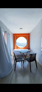 a dining room with a table and two chairs at Amsterdam Lofts Deluxe in Poços de Caldas