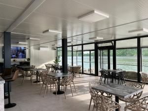 a dining room with tables and chairs and windows at Complex Turistic Emilio in Sviniţa