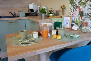 a table with food and drinks on it in a kitchen at Une virée à deux, gîte et spa in Guiscard