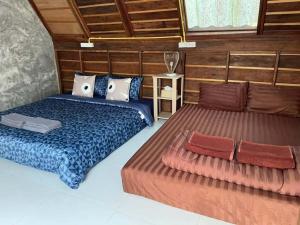 two beds in a room with wooden walls at Zerohouse in Ban Bang Bao +28 photos