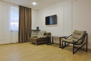 a living room with a table and a chair and a television at Ani Hotel in Maralik