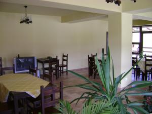 ein Esszimmer mit Tischen, Stühlen und einer Pflanze in der Unterkunft Pensiunea DALIA in Lepşa
