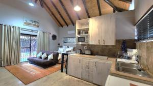 a kitchen with a couch and a table in a room at Marloth Wild Fig Studio in Marloth Park