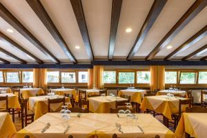 a dining room with tables with yellow table cloth at Hotel Appennino in Fiumalbo