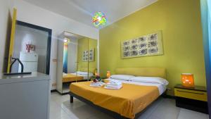 a bedroom with two beds and a yellow wall at LA BAIA DI NETTUNO Il Gatto e La Volpe in Venetico