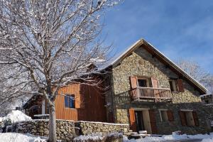 a stone house with a tree in front of it at Chalet Mounette Ski Sauna Lac Embrun in Puy-Sanières