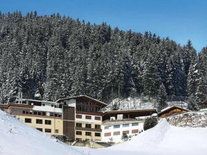 een gebouw op een met sneeuw bedekte berg met bomen bij Haus Wildbach in Kappl