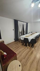 a room with a large white table and chairs at Chata Pod Skarpą in Wieprzec