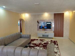 a living room with a couch and a flat screen tv at Kelhanil Homes in Narok