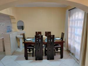 a dining room table with chairs and a kitchen at Kelhanil Homes in Narok
