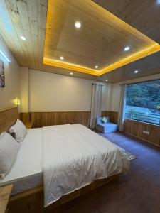 a bedroom with a large bed in a room at Riverdale Cottage and Cafe Jibhi in Jibhi