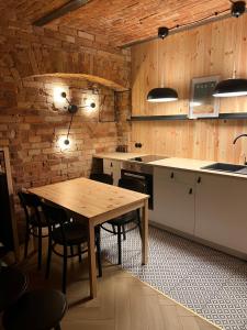 a kitchen with a wooden table and some chairs at Apartament M6 in Leśna