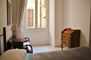 - une chambre avec un lit, une commode et une fenêtre dans l'établissement Roman Central House, à Rome