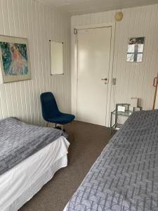 a bedroom with a bed and a blue chair at Munkebo B&B, Thy in Thisted