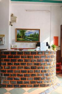a brick counter with a painting on the wall at Kiến An Hotel Cần Thơ in Can Tho
