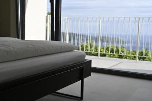 a bedroom with a bed and a large window at Luxury stone house with infinity pool in Herceg-Novi