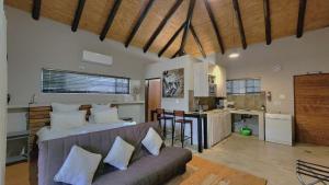 a living room with a couch and a kitchen at Marloth Wild Fig Studio in Marloth Park
