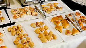 a table topped with white plates filled with pastries at Apoema Hotel in Cuiabá +17 photos