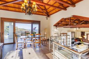 a kitchen and dining room with wooden ceilings at Gallis Villa in Pefkias