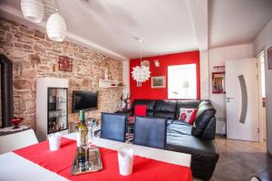 salon z czarną skórzaną kanapą i czerwonymi ścianami w obiekcie Villa Tudor w mieście Grohote