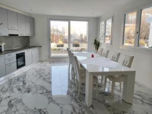 a white kitchen with a white table and chairs at Apartments Marini in Pordenone