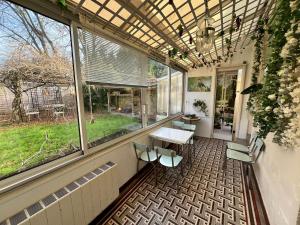 a screened in porch with a table and chairs at Guynemer 8pers in Nantes