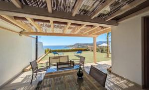 a patio with a view of the ocean from a house at La Costa Est Villa con Vista Mare in Ogliastra Sardegna in Tertenìa