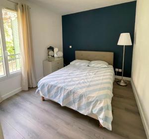 a bedroom with a bed with a blue wall at Appartement 3P Nice in Nice